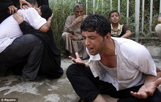 Image of despair: Iraqis outside a morgue mourn the family victims of a bomb attack in Baghdad which killed 47 people